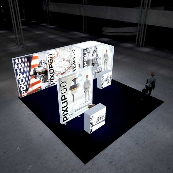 A modern trade fair booth with PIXLIPGO branding, featuring bright white illuminated frames showcasing high-precision mechanical components and an American flag. A woman in business attire observes the exhibit from the side